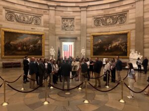 Utah Valley Chamber delegation touring a historic rotunda with American artwork and statues.